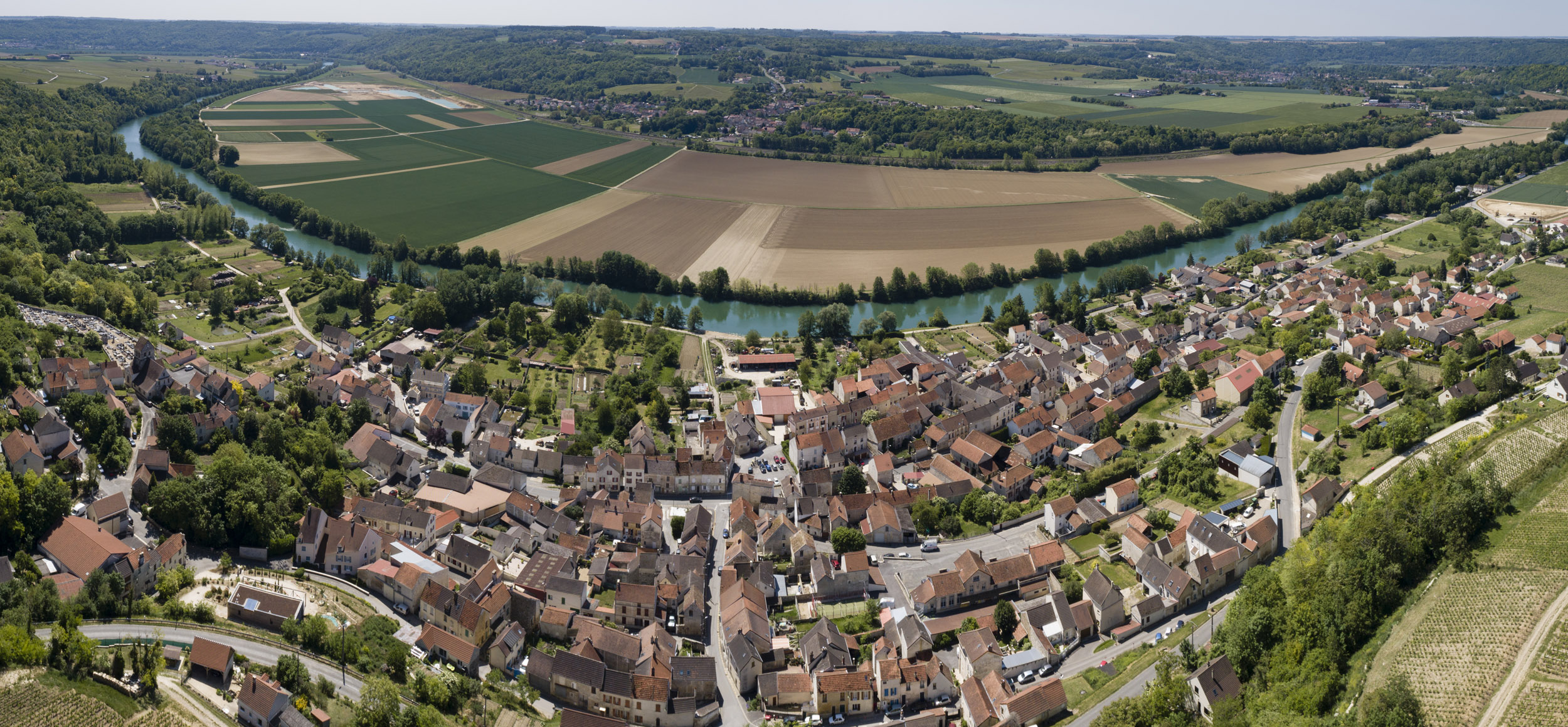 Vue aérienne panoramique de paysage par drone du village de Crouttes-sur-Marne, on distingue les tuiles rouges des toits des maisons, la vigne, la marne et les champs