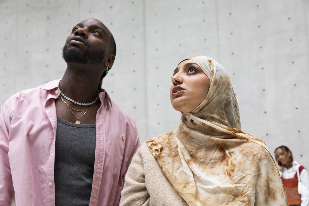 Un homme et une femme côte à côte regardent vers le haut la coupole à l'intérieur de la Bourse du Commerce, photo réalisée en contre plongée