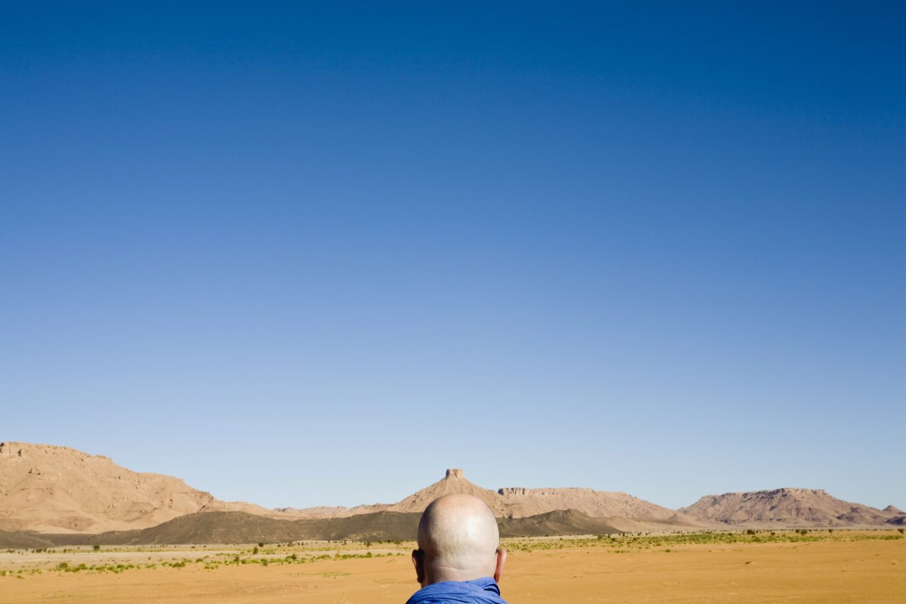 Photo créative d'un homme qui marche dans le désert